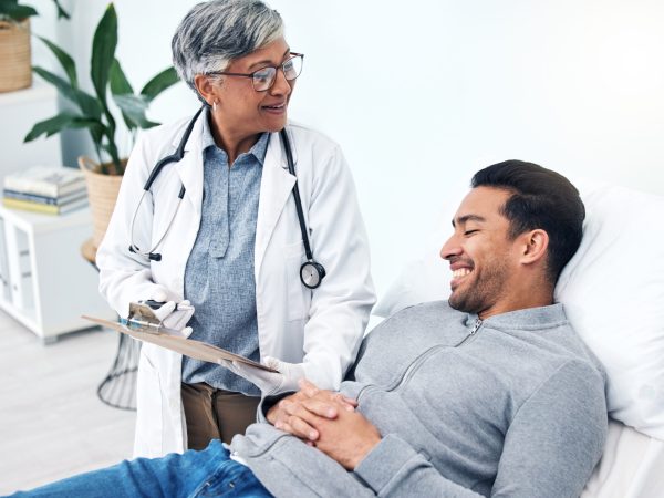 Man, doctor and insurance report with talk and senior professional at a hospital for health. Wellne.